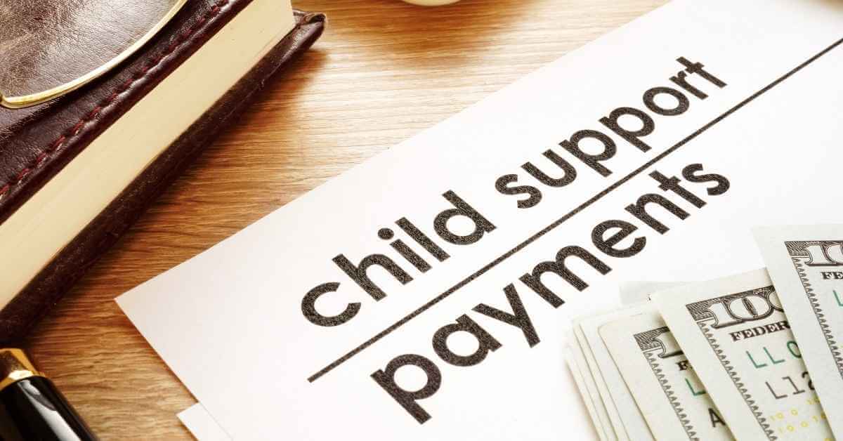 Papers that read "child support payments" with a few hundred dollars resting in the corner